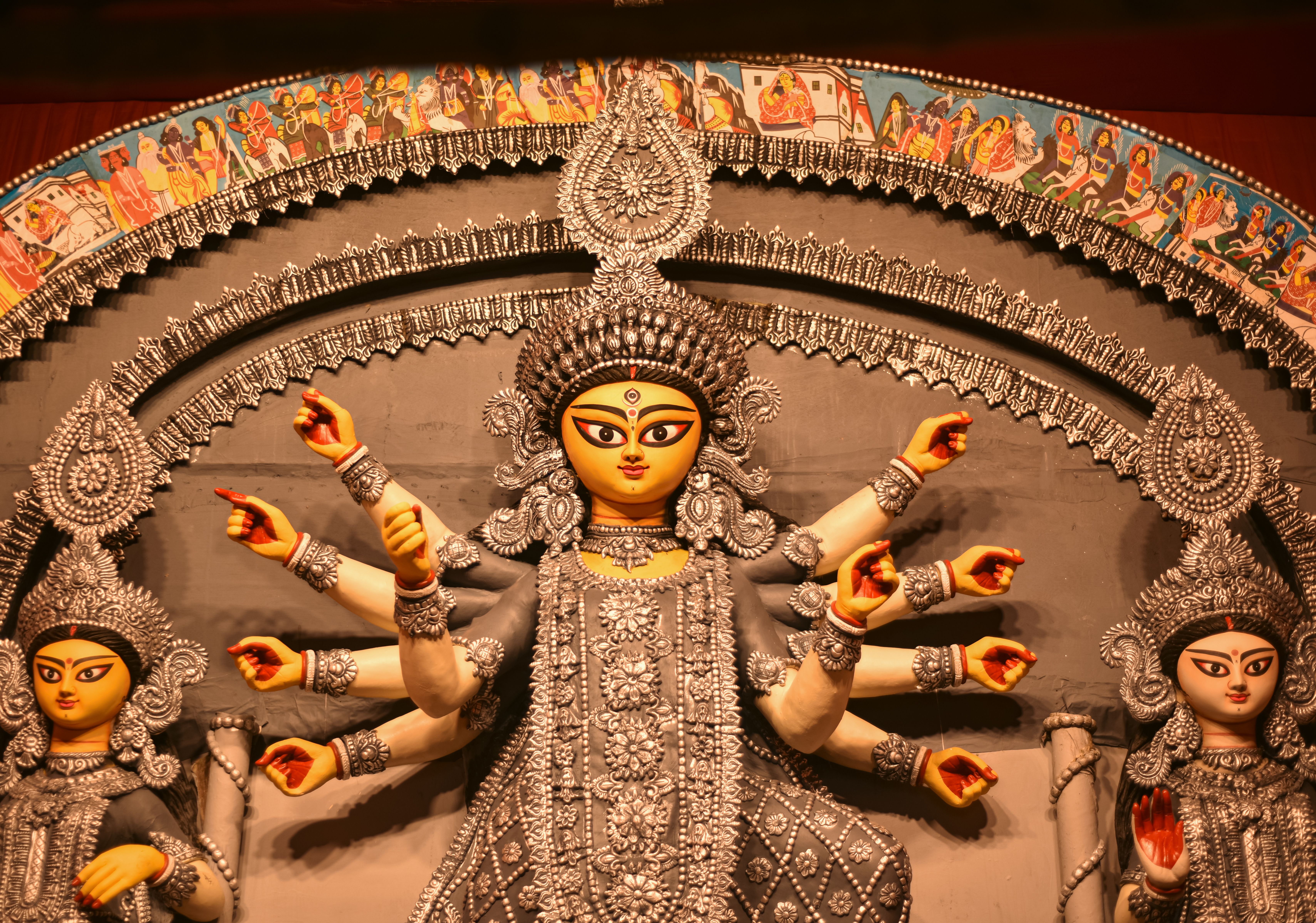 Durga's idol beneath an ornate arch with a painted folk-art border — photo via Pexels / Souvik Dutta